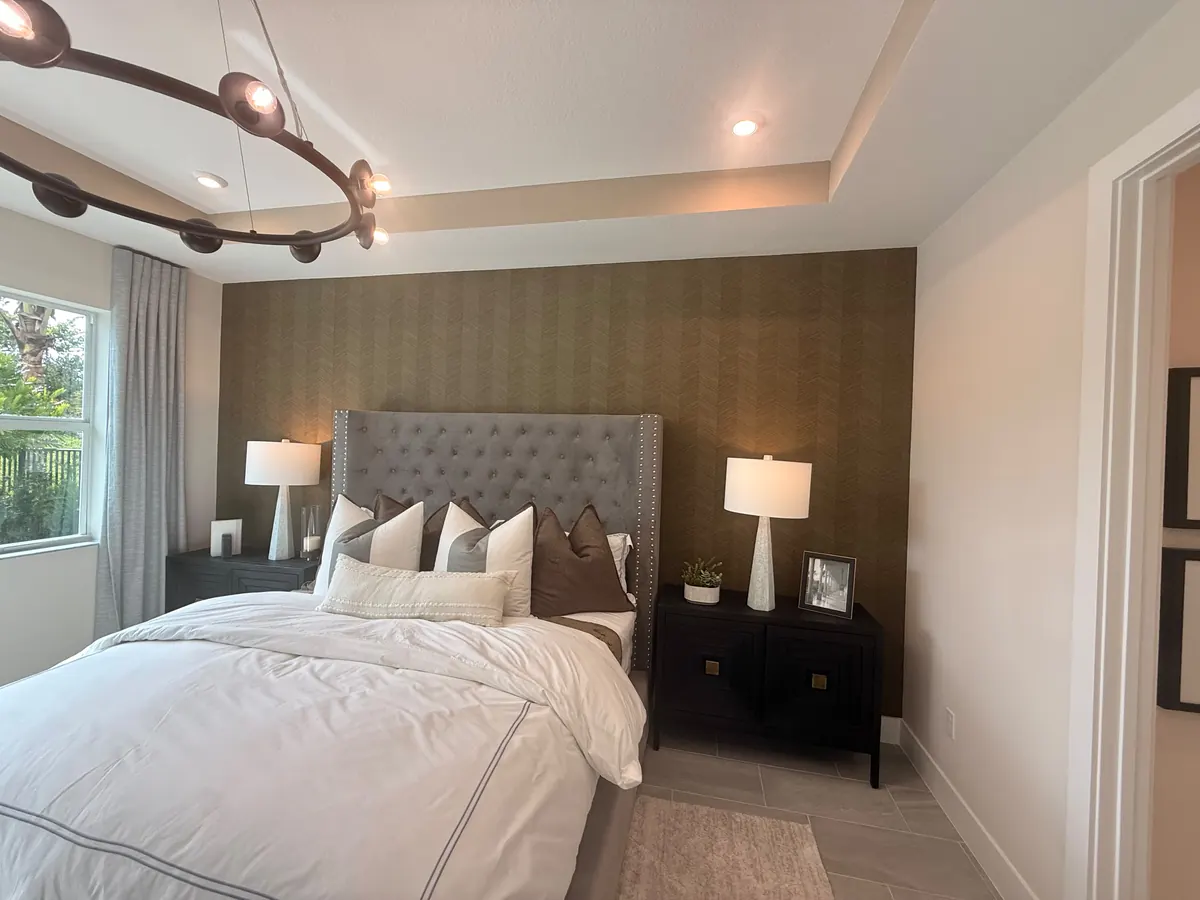 Bedroom with a textured wallpaper accent wall behind the bed