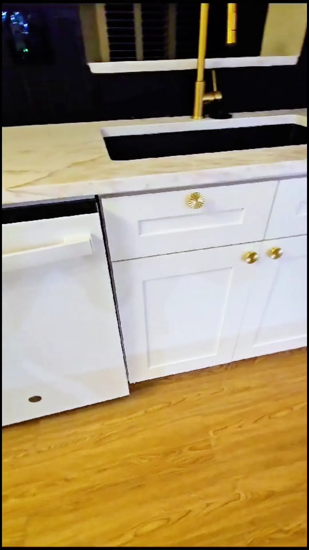 Sink base with shaker doors, gold knobs and a gold faucet